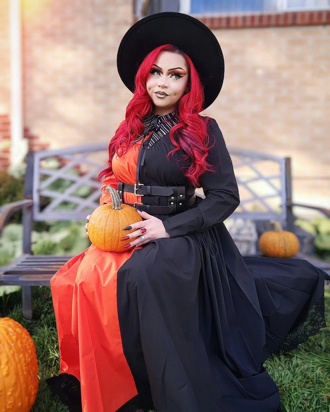 black outfit with wide-brim hat, fitted torso, broad skirt, and visible warm underlayer