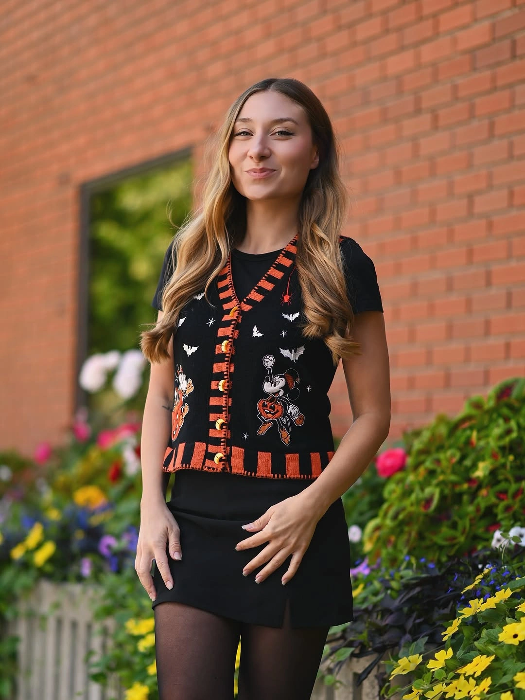 black outfit with plain dark base under fitted graphic vest