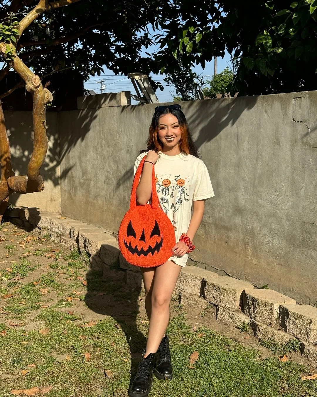 white outfit with loose tee over short bottoms with sturdy boots and oversized tote