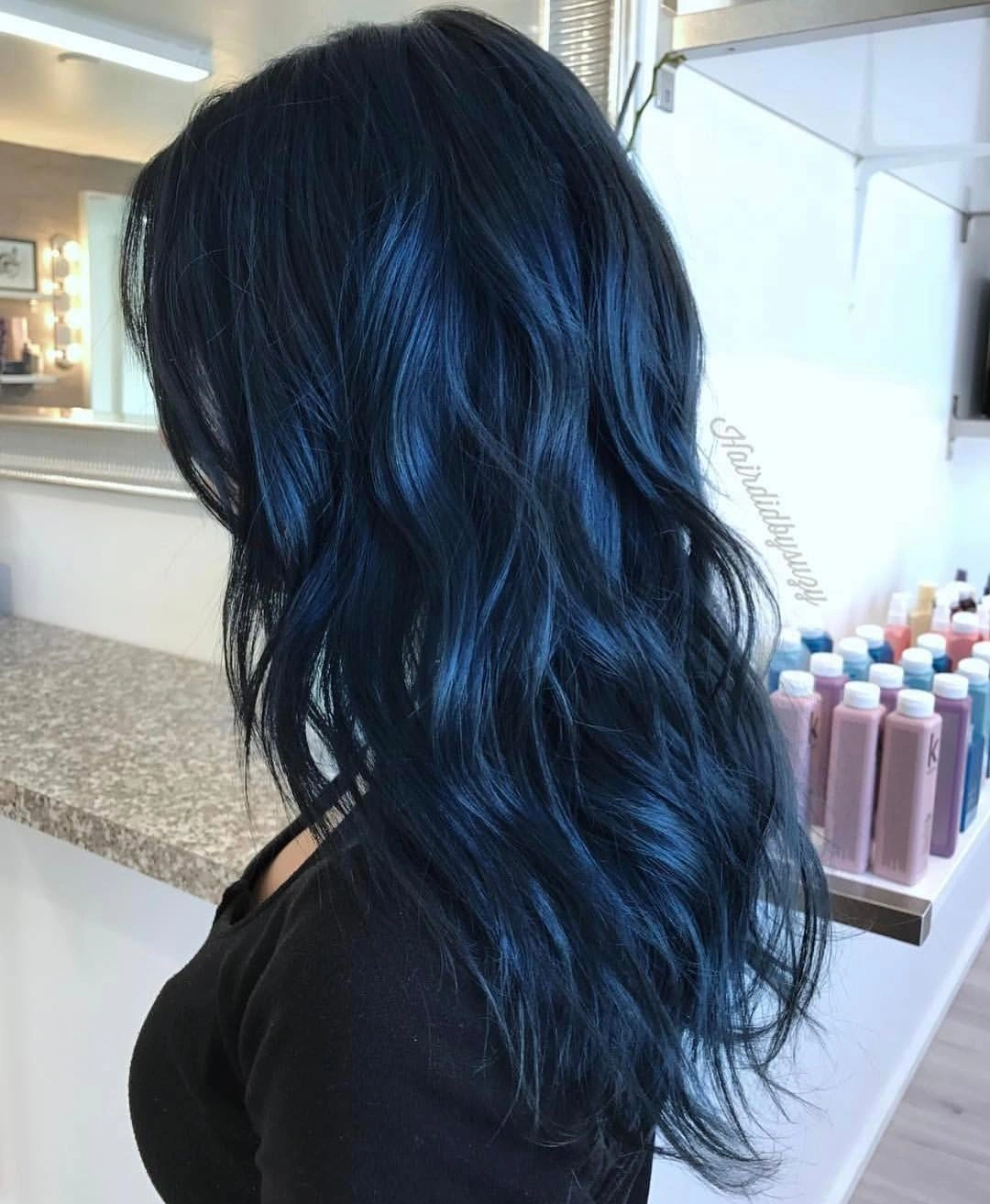 Long blue-black waves with vivid cobalt reflections across the surface