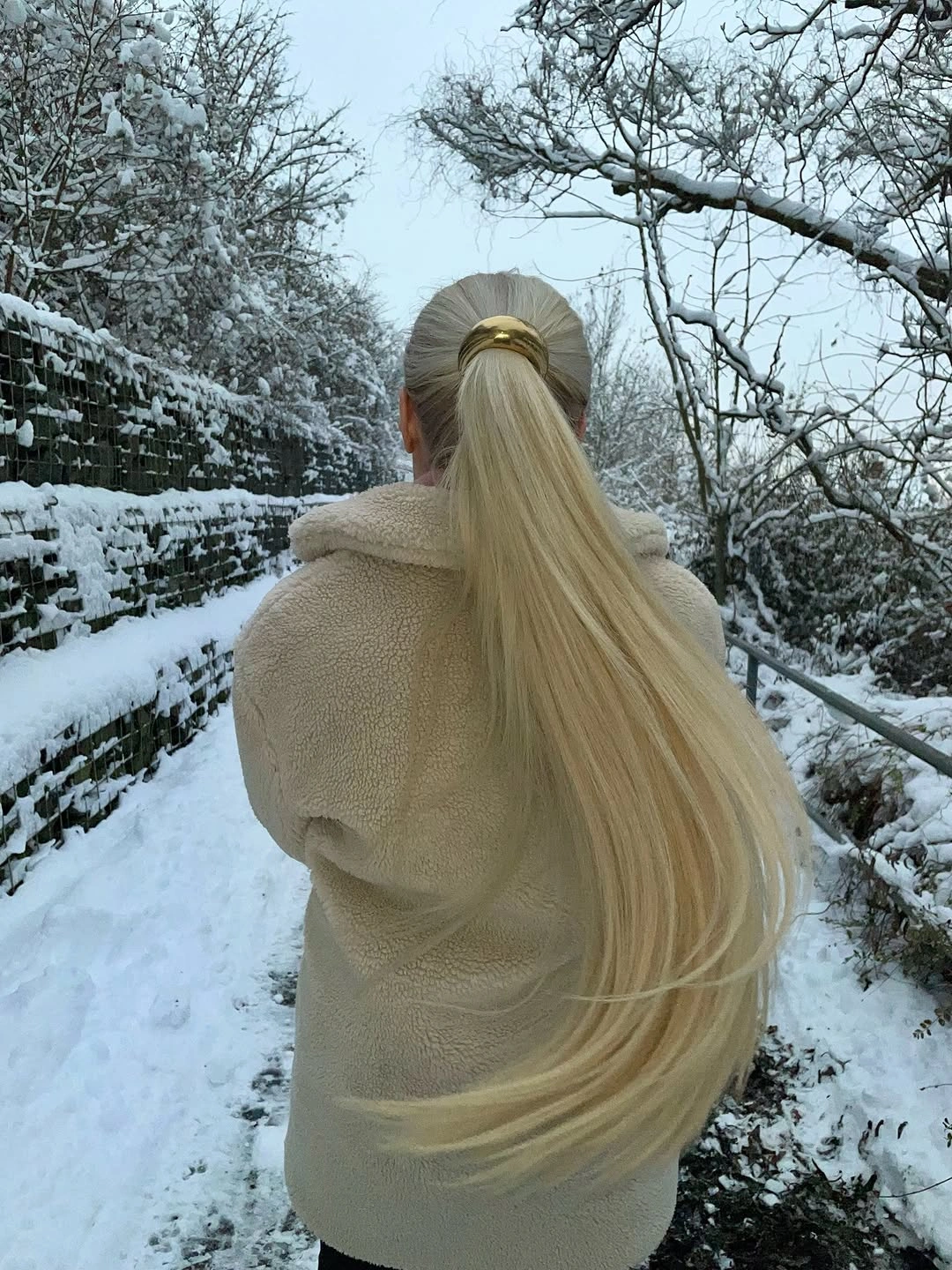 Extremely long mostly straight hair gathered into a smooth ponytail