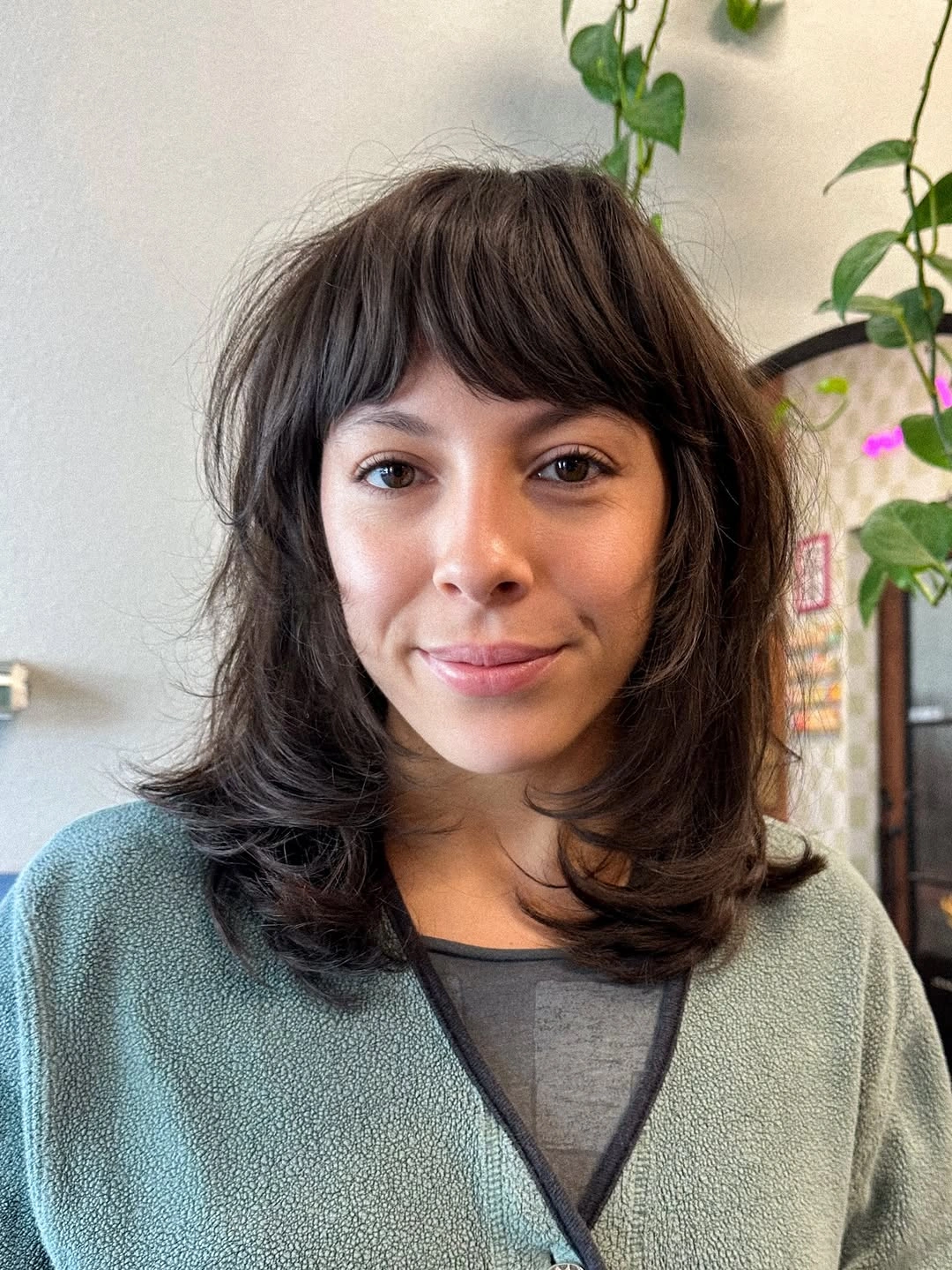 Medium dark hair with full bangs and flipped layered ends