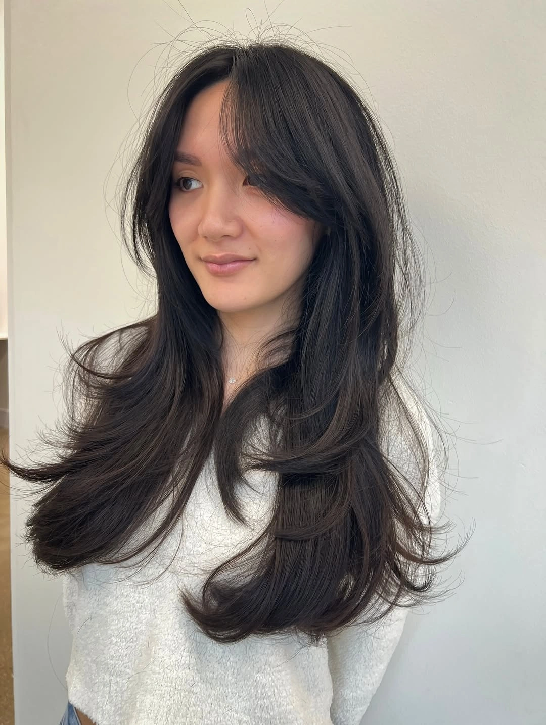 Very long dark hair with cascading curved face-framing layers