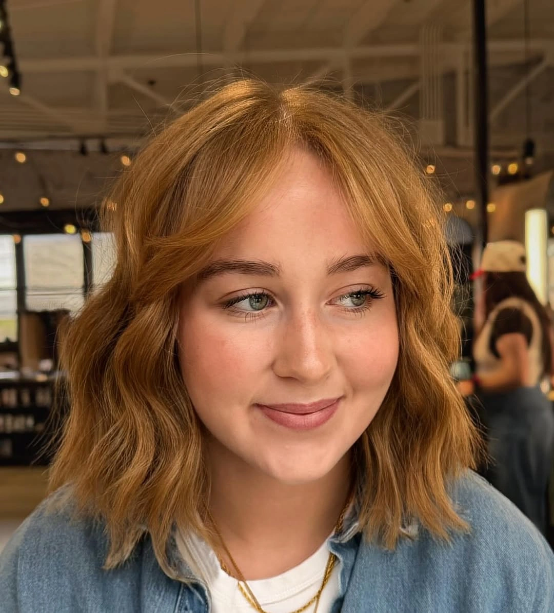 Wavy shoulder-length hair with open center and curved face framing