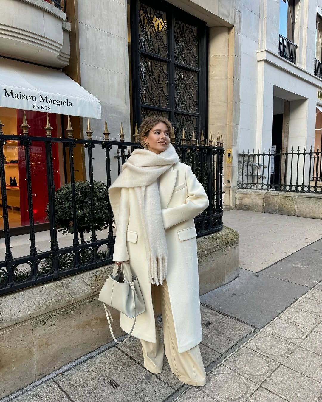 Long cream coat with oversized scarf and pale wide trousers