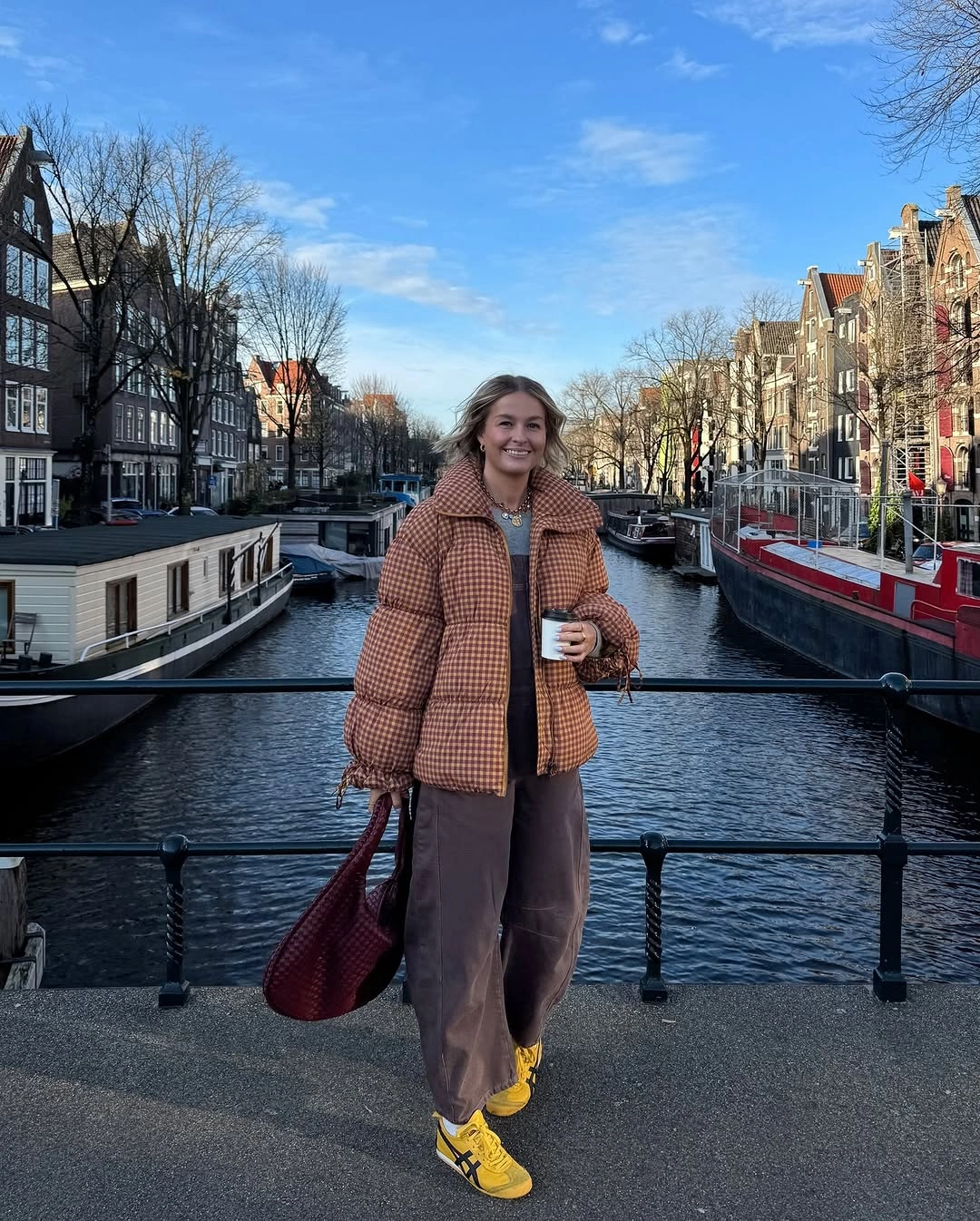 Checked puffy jacket, brown wide pants and yellow sneakers