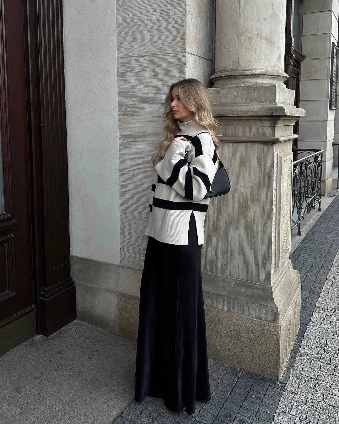 Cream striped sweater, long black skirt, black shoulder bag