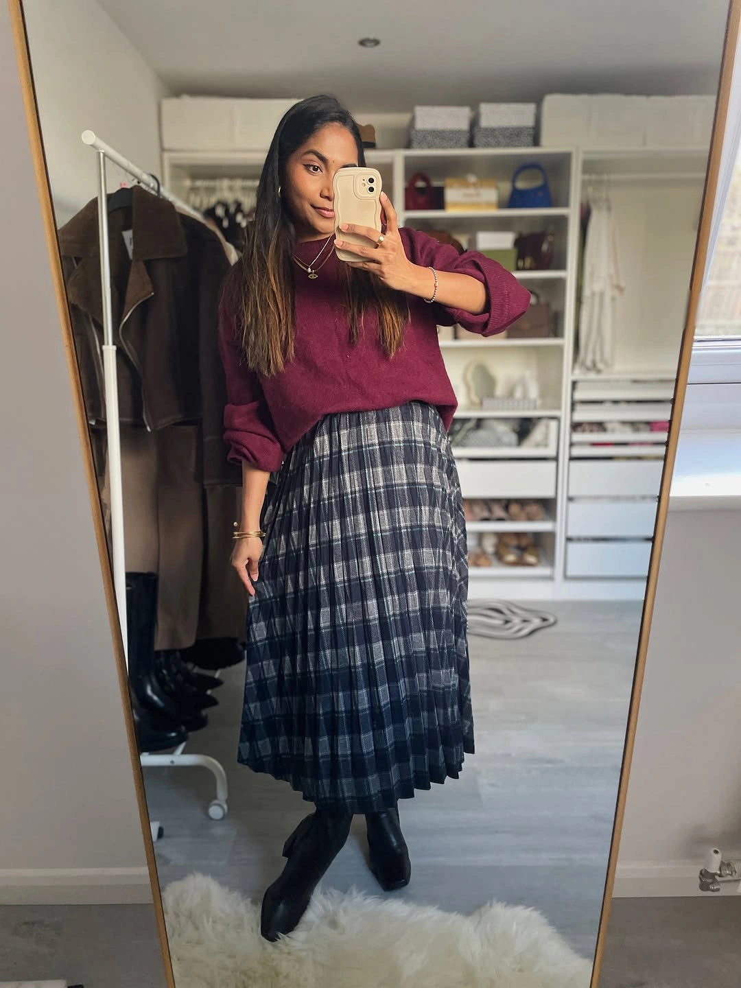 Burgundy sweater, blue-gray plaid pleated midi skirt, black boots