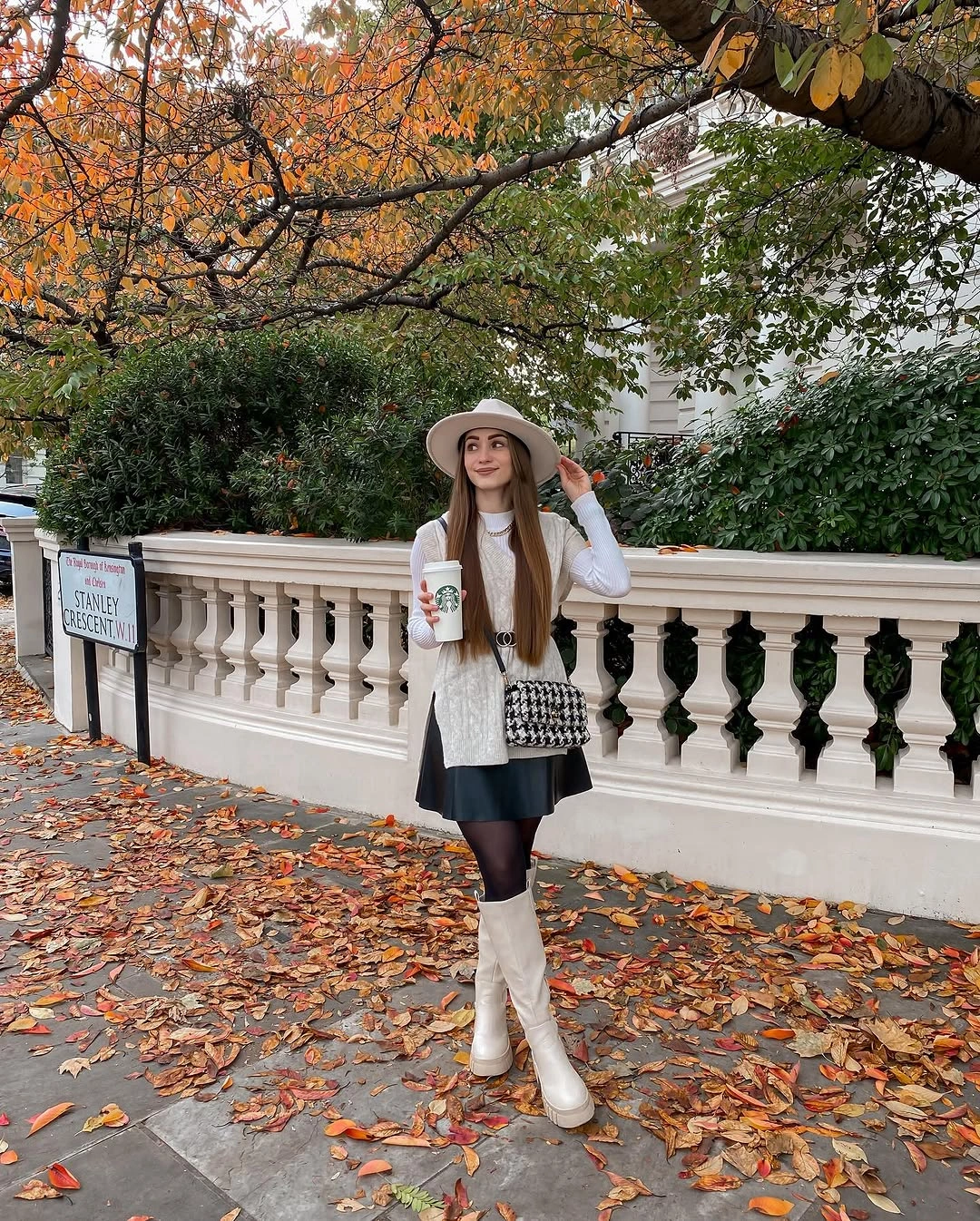Black mini skirt, dark tights, white boots, pale hat