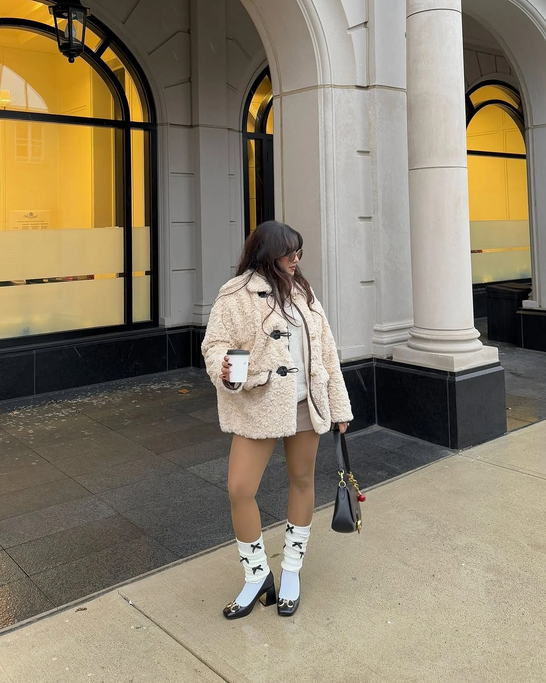 Cream textured jacket with bow socks and black heeled shoes