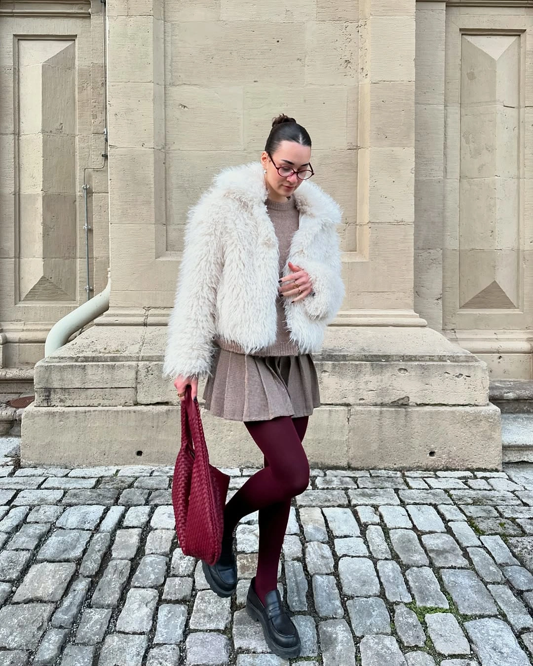 Shaggy white jacket with taupe pleated skirt and burgundy tights