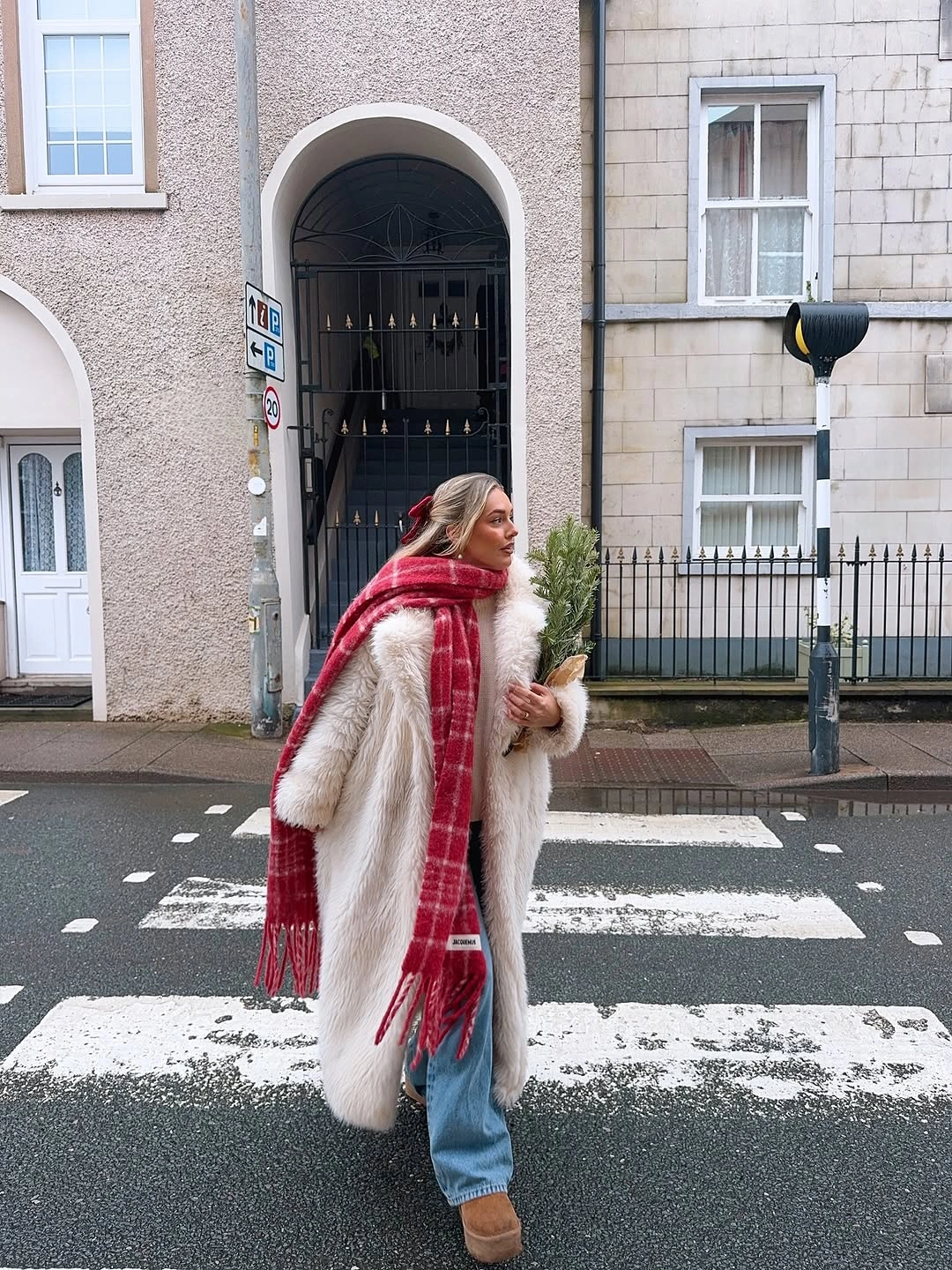 Cream textured coat with red plaid scarf, jeans, tan boots