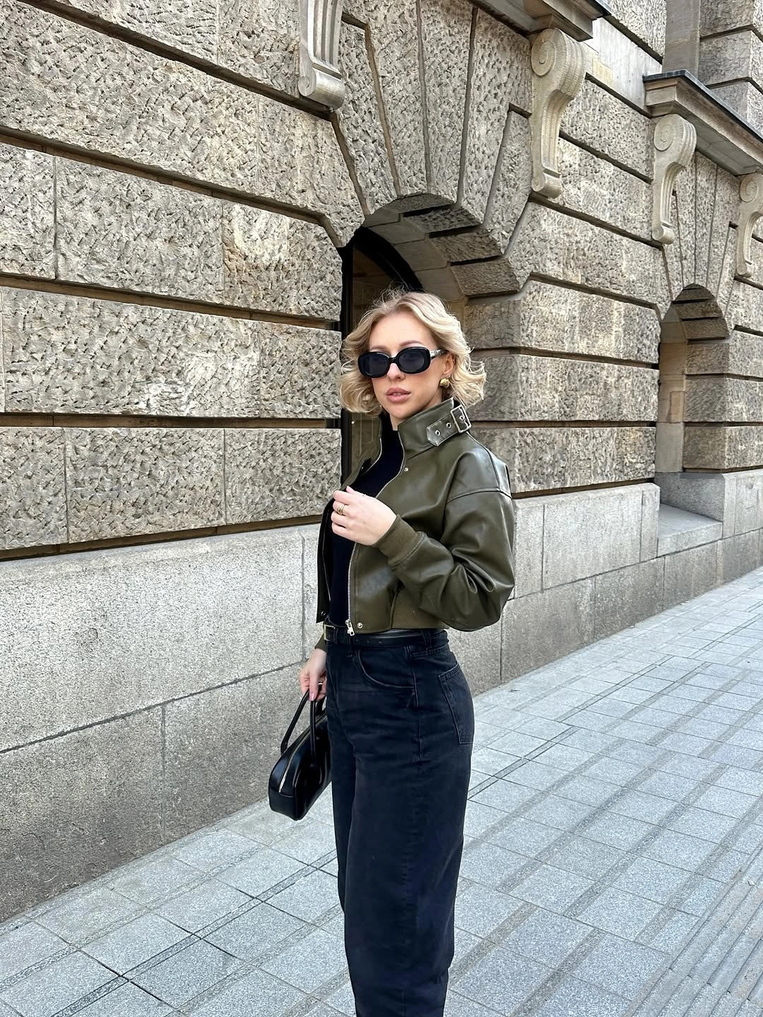 Cropped olive jacket with black top and dark high-waisted base