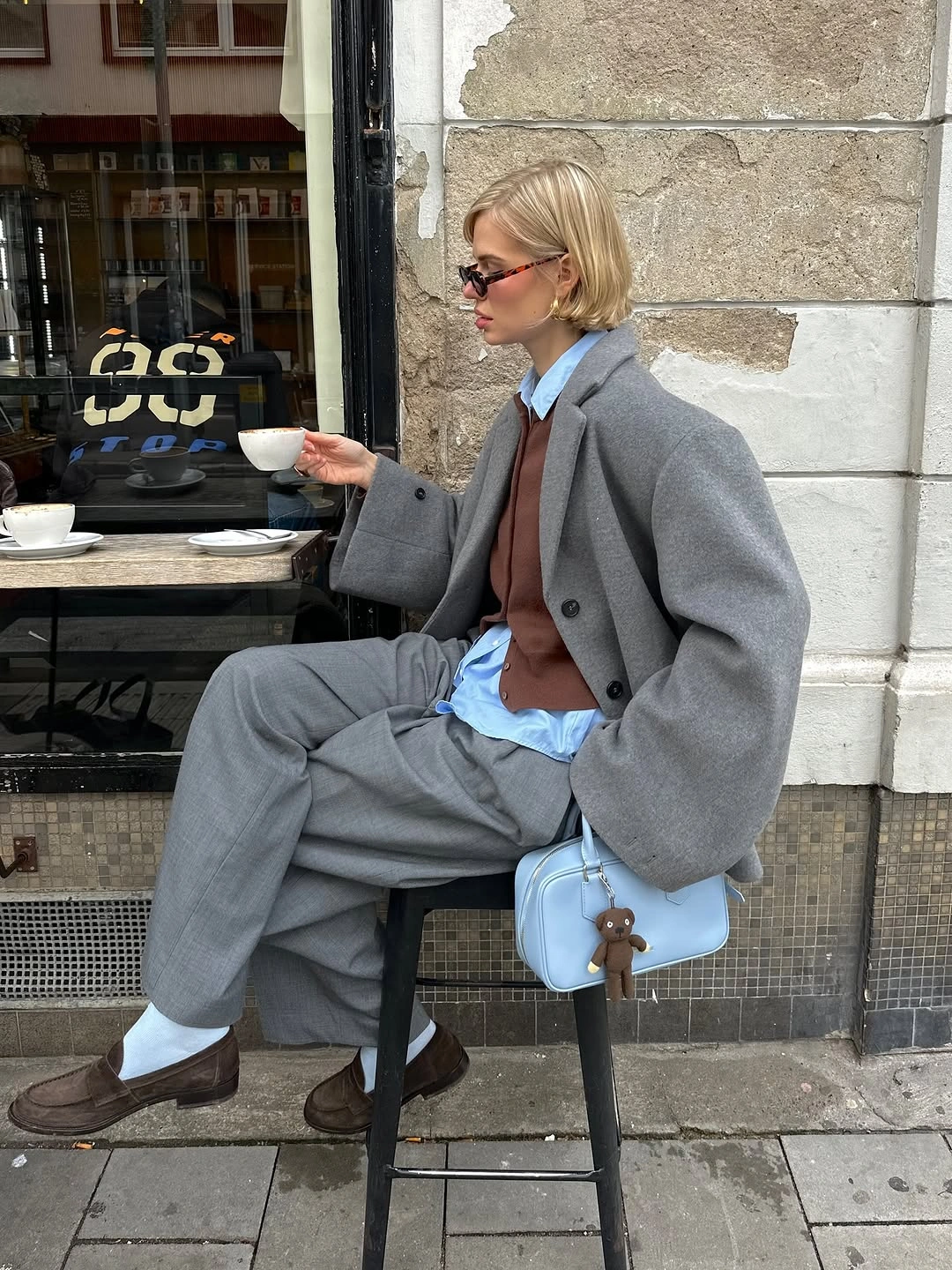 Oversized gray layer with relaxed trousers and pale blue bag