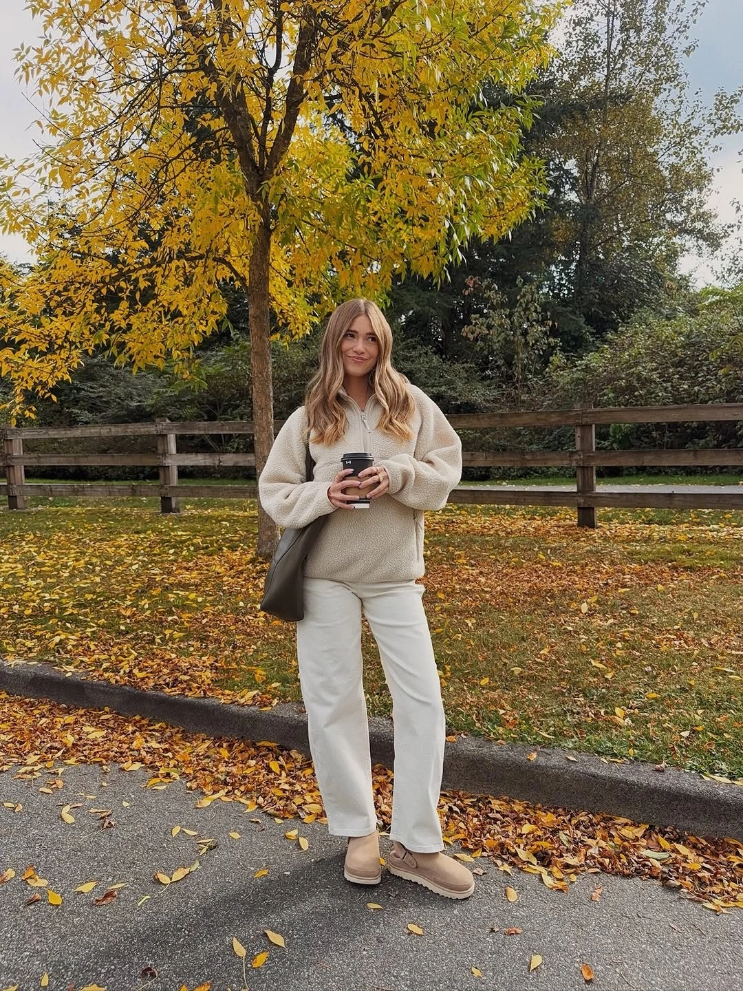 Pale pullover with light straight trousers and darker shoulder bag