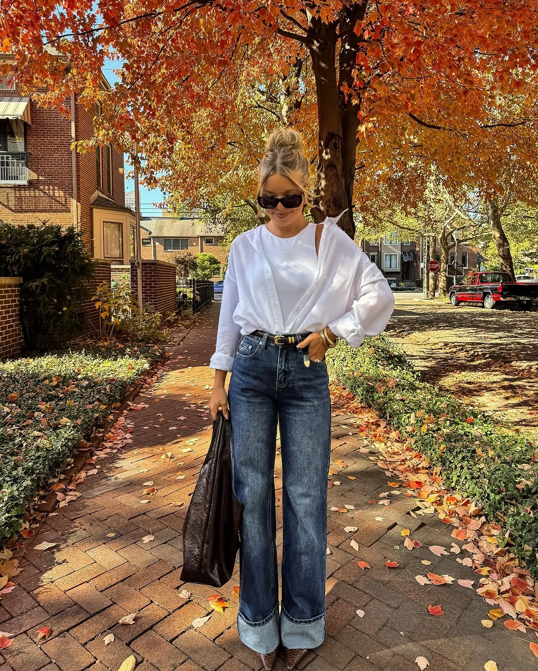 Oversized white shirt with wide cuffed jeans and pointed brown footwear
