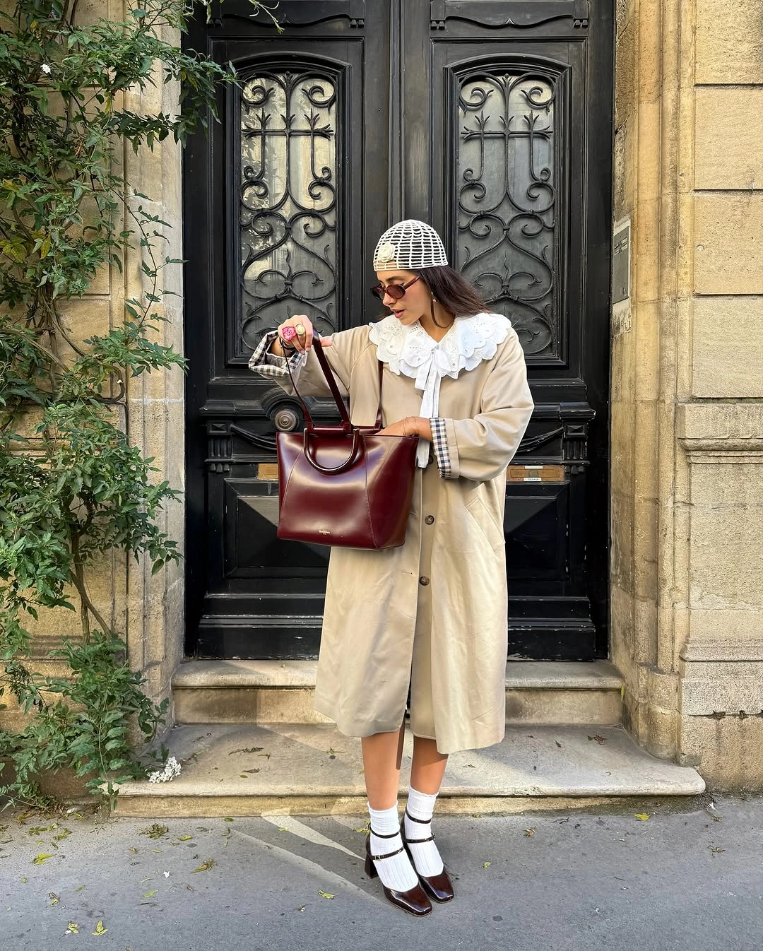 Long neutral coat with white collar burgundy bag and strap shoes