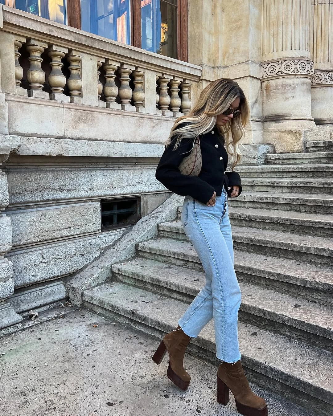 Short black jacket with light blue jeans and brown heeled boots