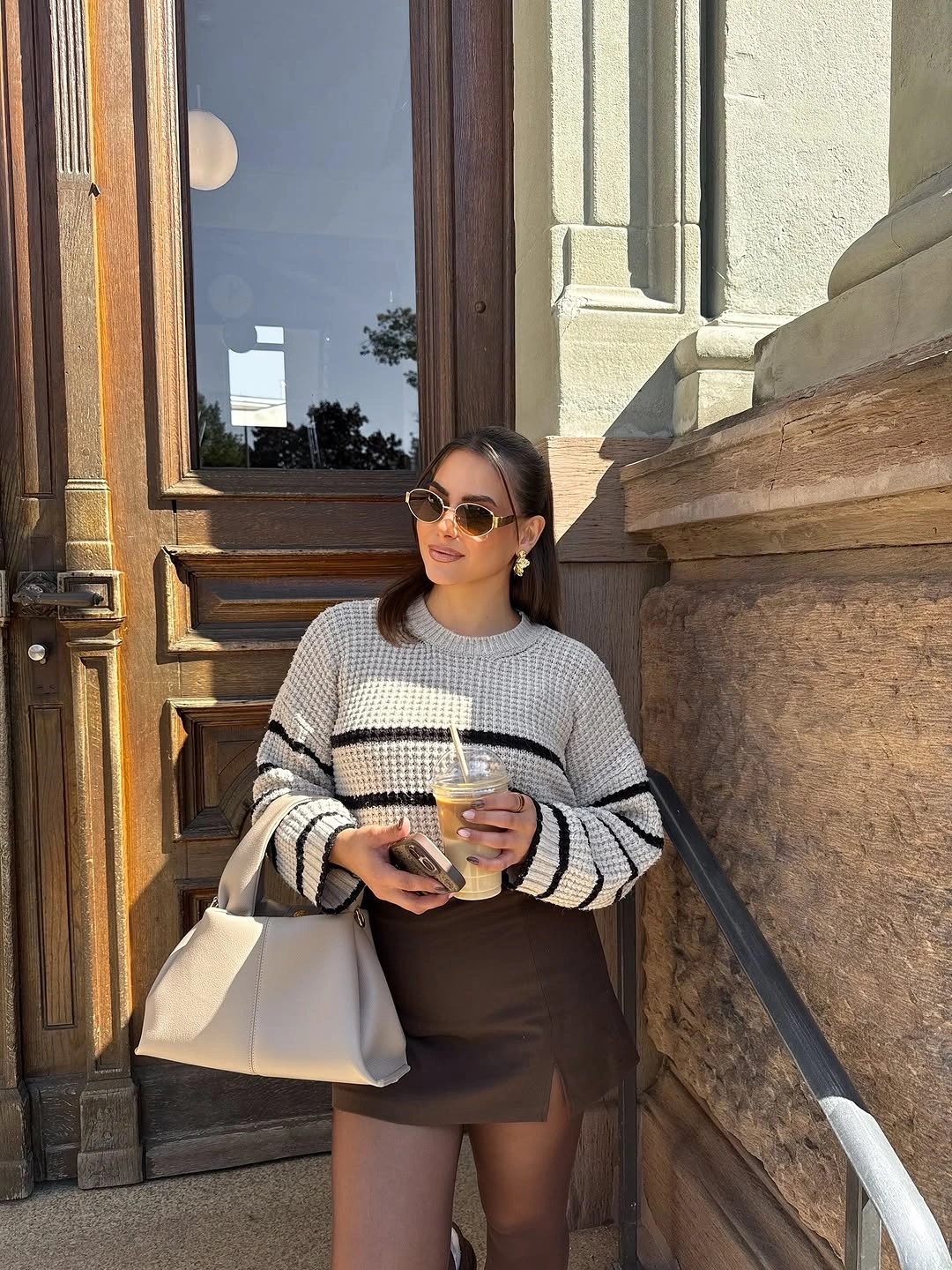 Gray striped top with brown mini skirt and pale structured tote