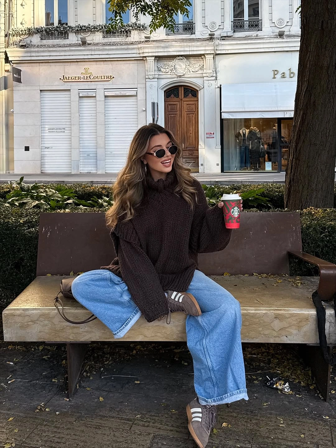 Oversized dark brown turtleneck with wide light-blue jeans and sneakers