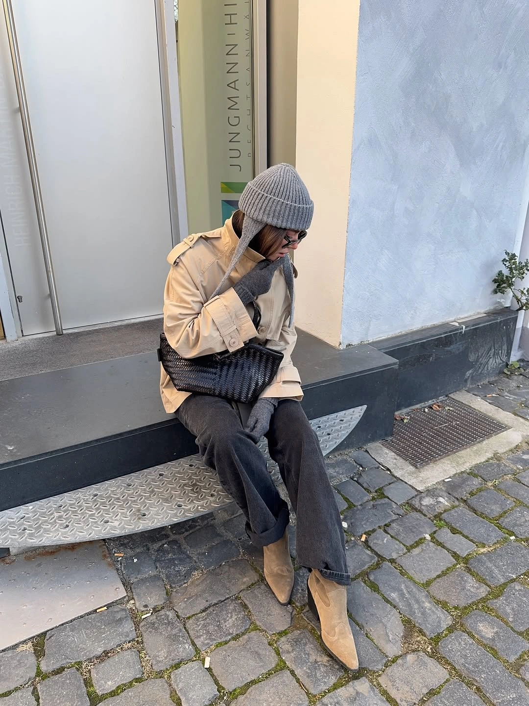 Beige trench-style coat with gray accessories and tan boots