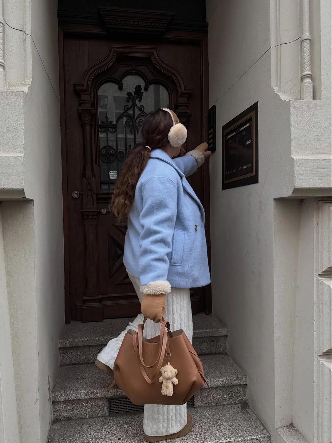 Light blue short coat with cream pants and tan tote