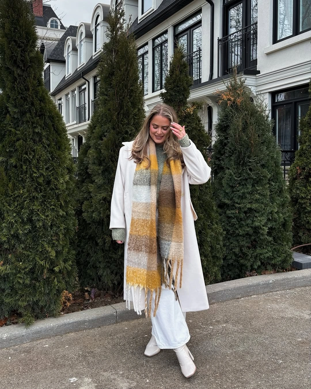 Long white coat with striped fringed scarf and white boots