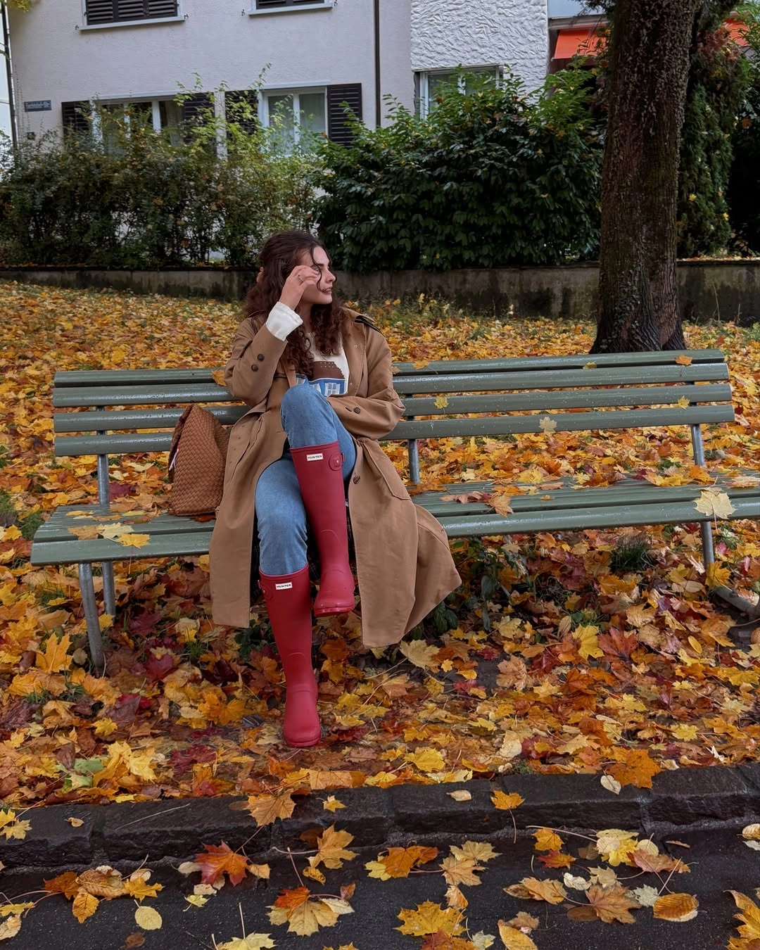 Camel long coat with blue jeans and tall red boots
