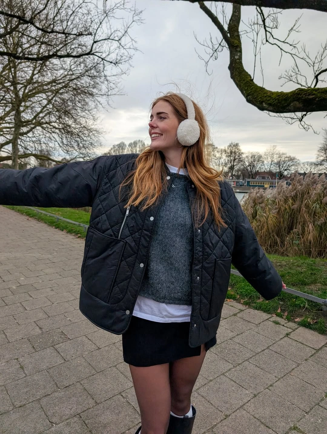 Black quilted-looking jacket with gray sweater and dark skirt