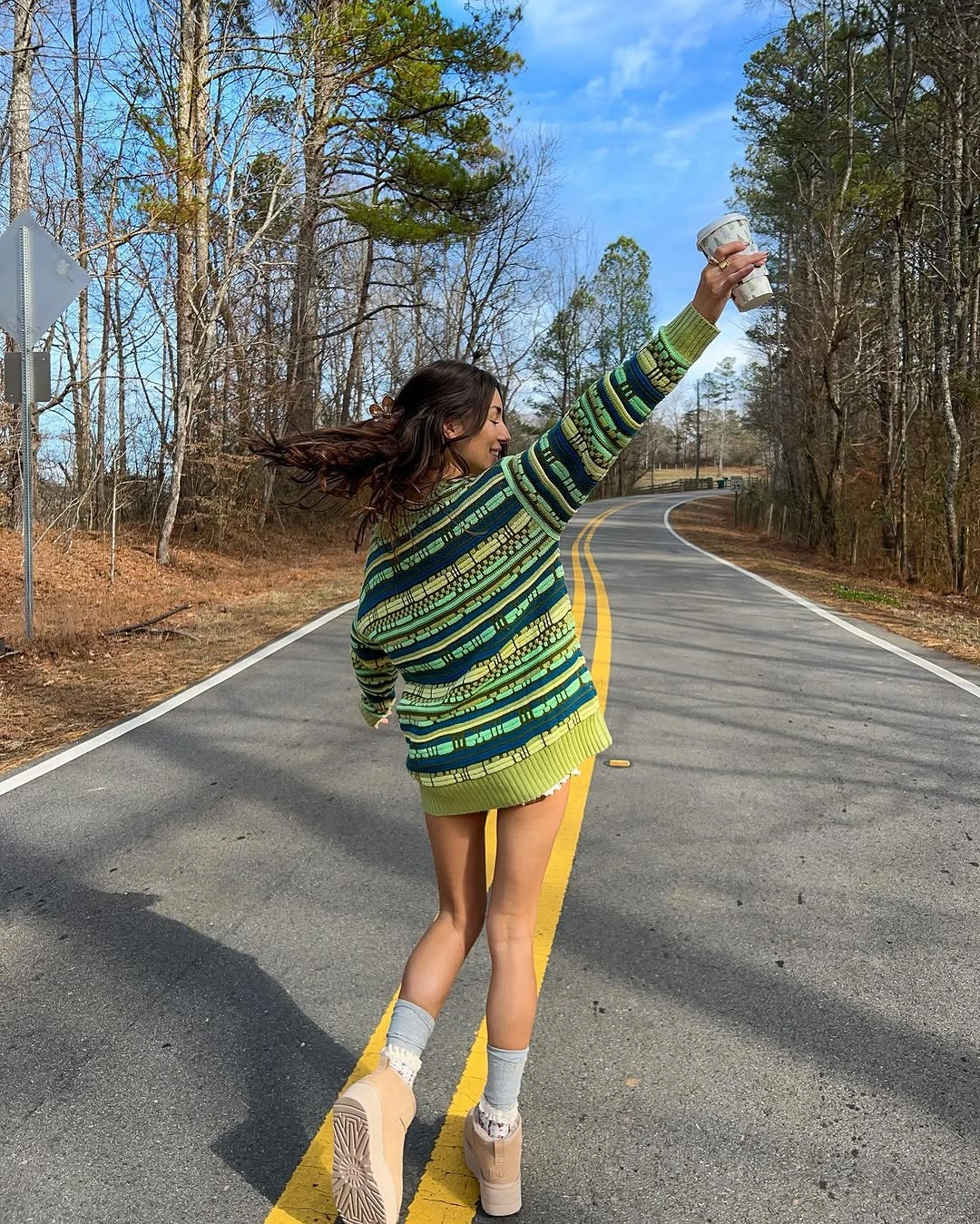 Oversized green striped sweater with white socks and beige sneakers
