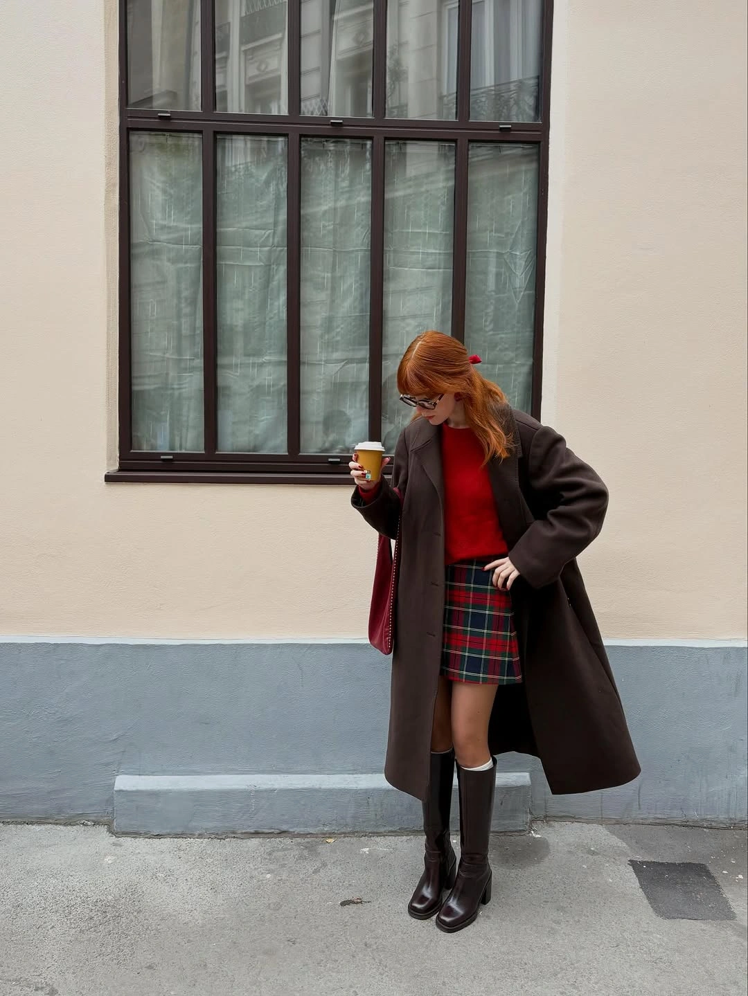 Dark brown long coat with red top and plaid mini skirt