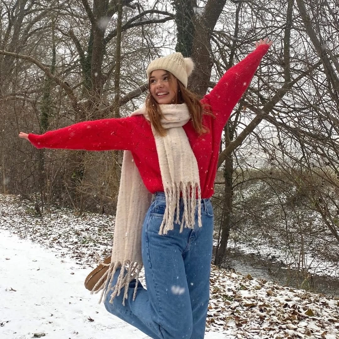 Red oversized sweater with cream scarf, beanie, and blue jeans