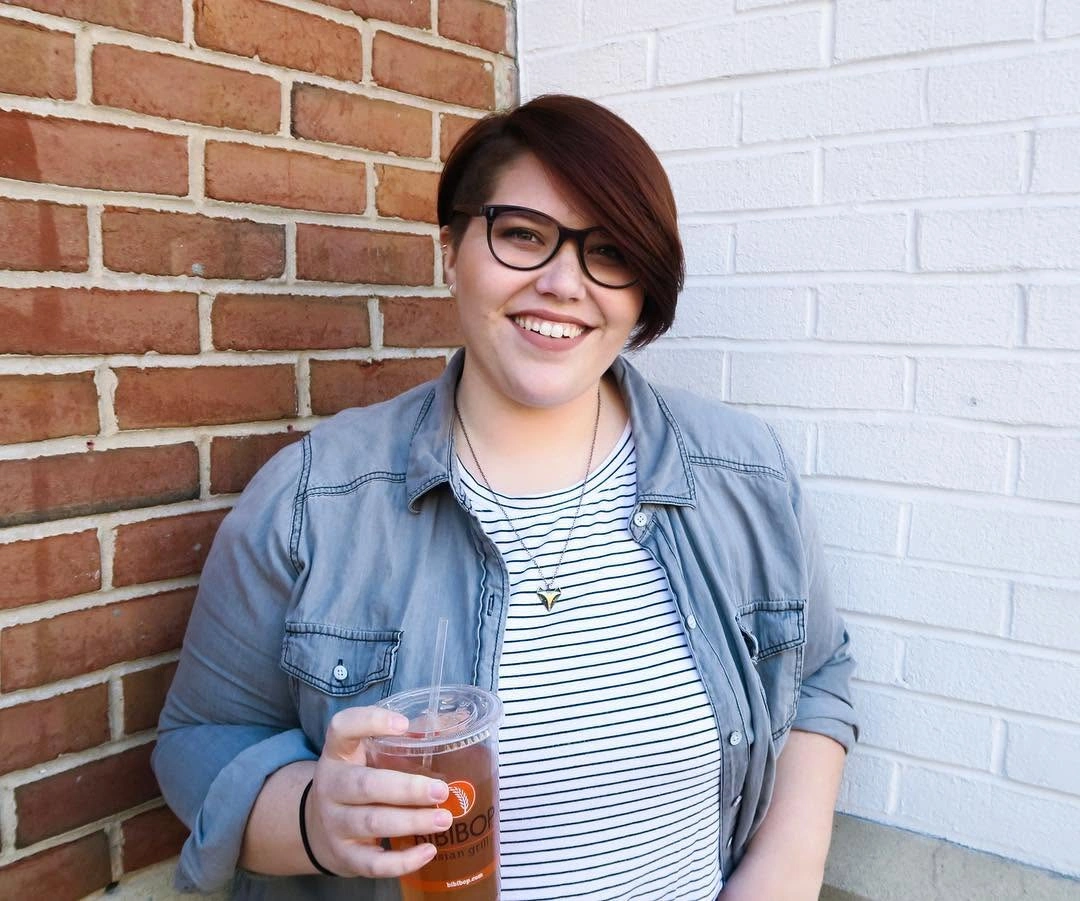 Side-swept auburn short cut with dark glasses