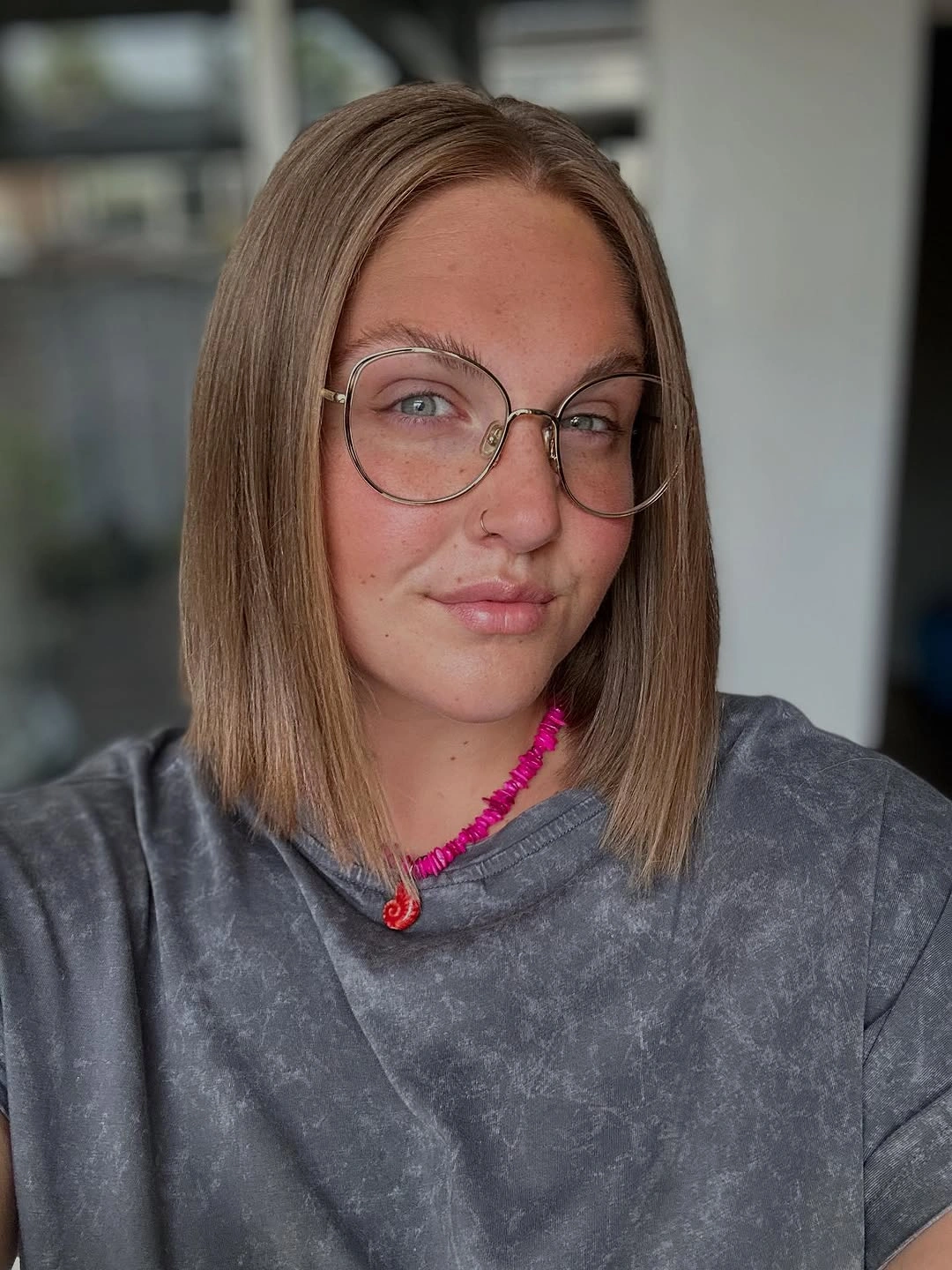 Straight blunt lob with center part and round glasses