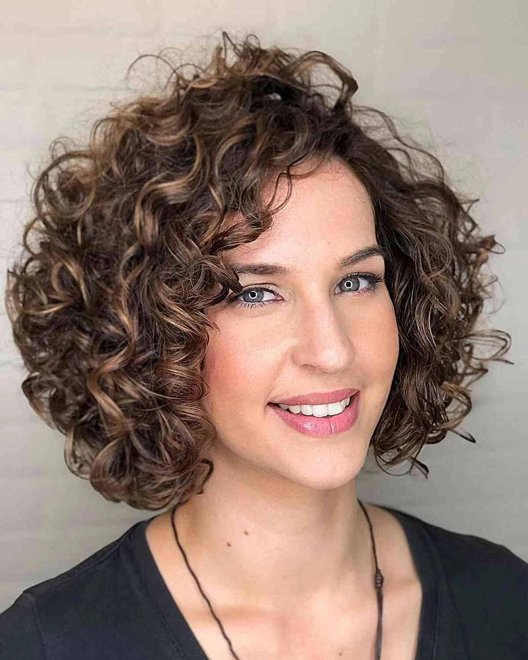 Layered curly bob with highlighted brown ringlets