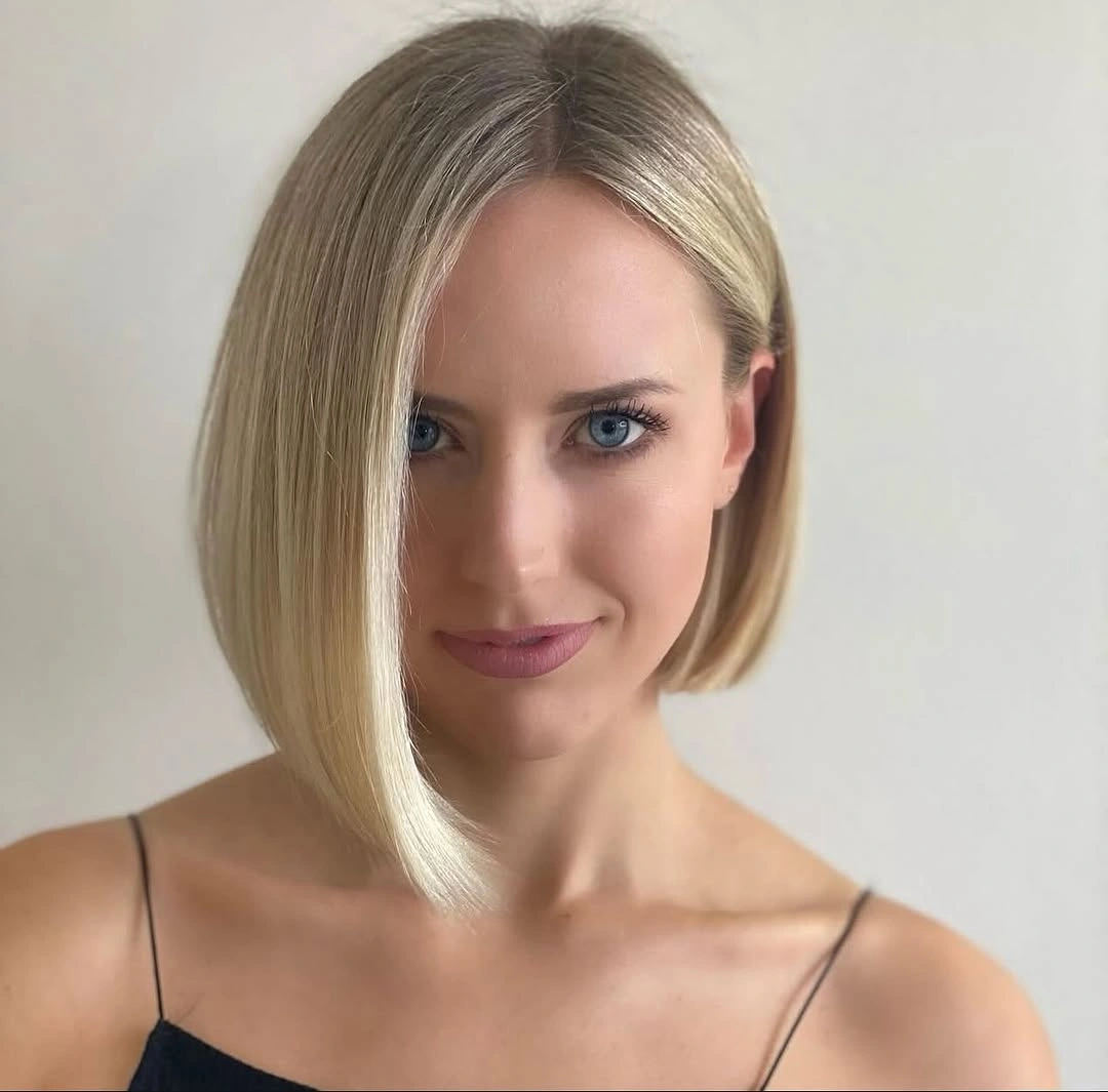 Sleek blonde angled bob with deep side part