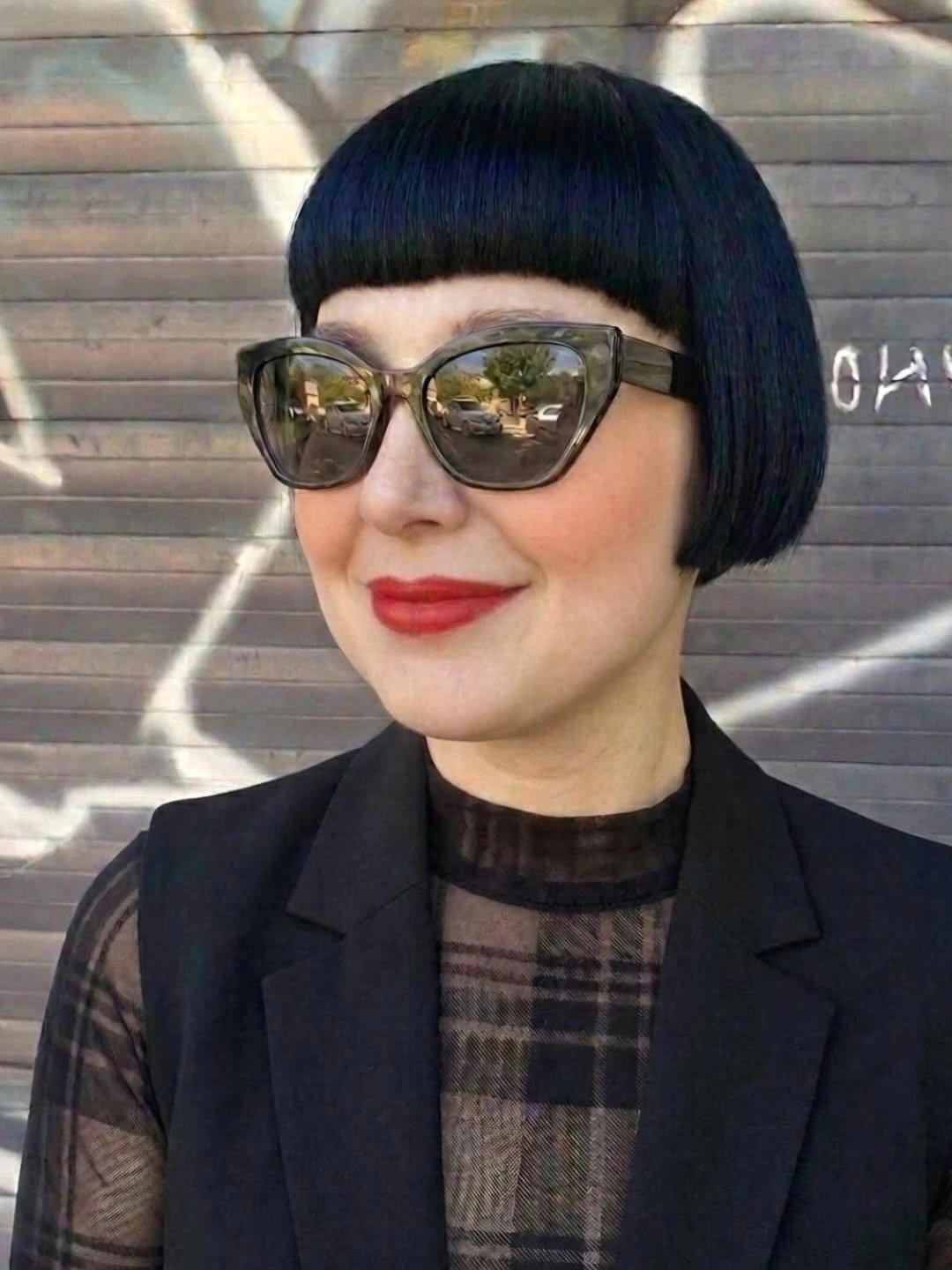 Glossy black bob with blunt bangs and sunglasses