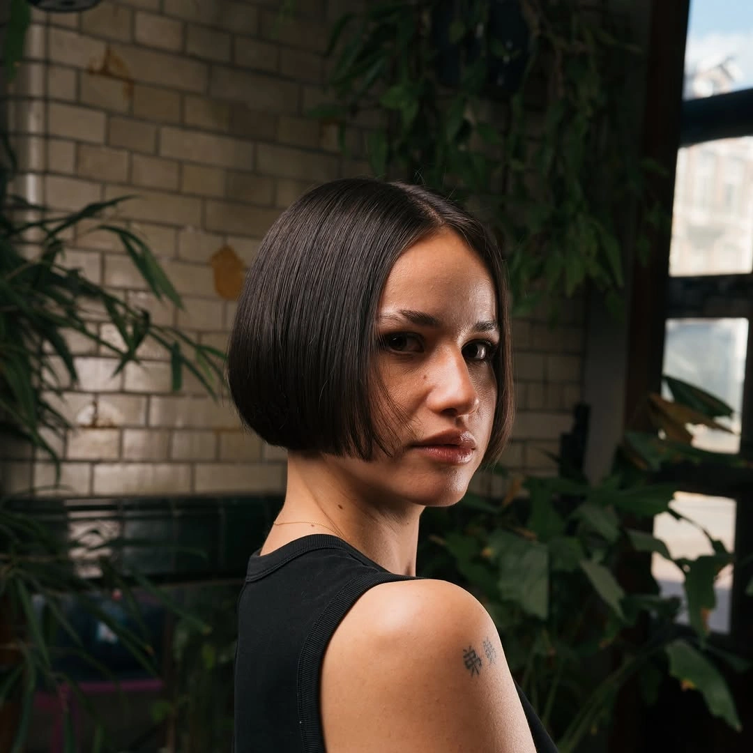 Dark chin-length bob with center part and tucked ends