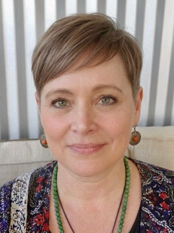 Soft taupe pixie with side fringe and green necklace