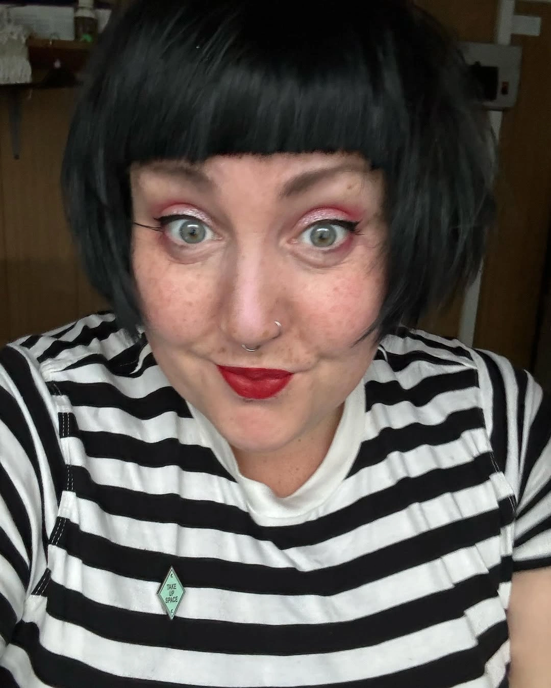 Black rounded bob with blunt bangs and striped top