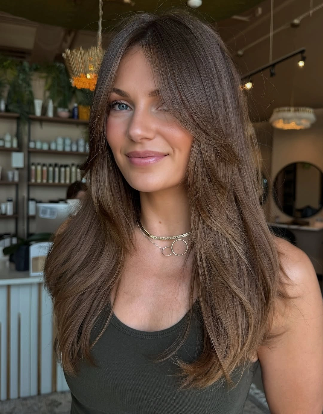 Long brown haircut with center part and soft face-framing layers