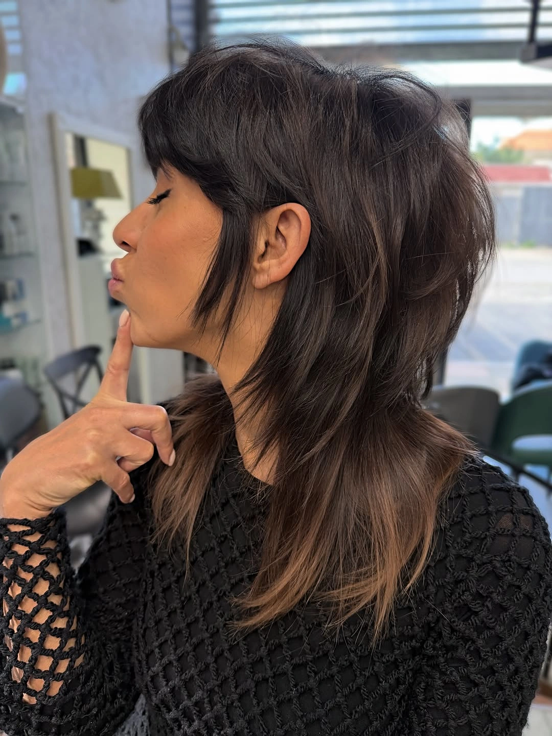 Medium dark shag haircut with short fringe and longer nape layers
