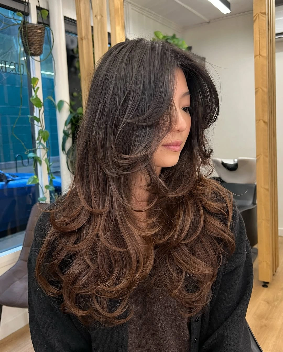 Long brunette haircut with large curtain layers and curled ends