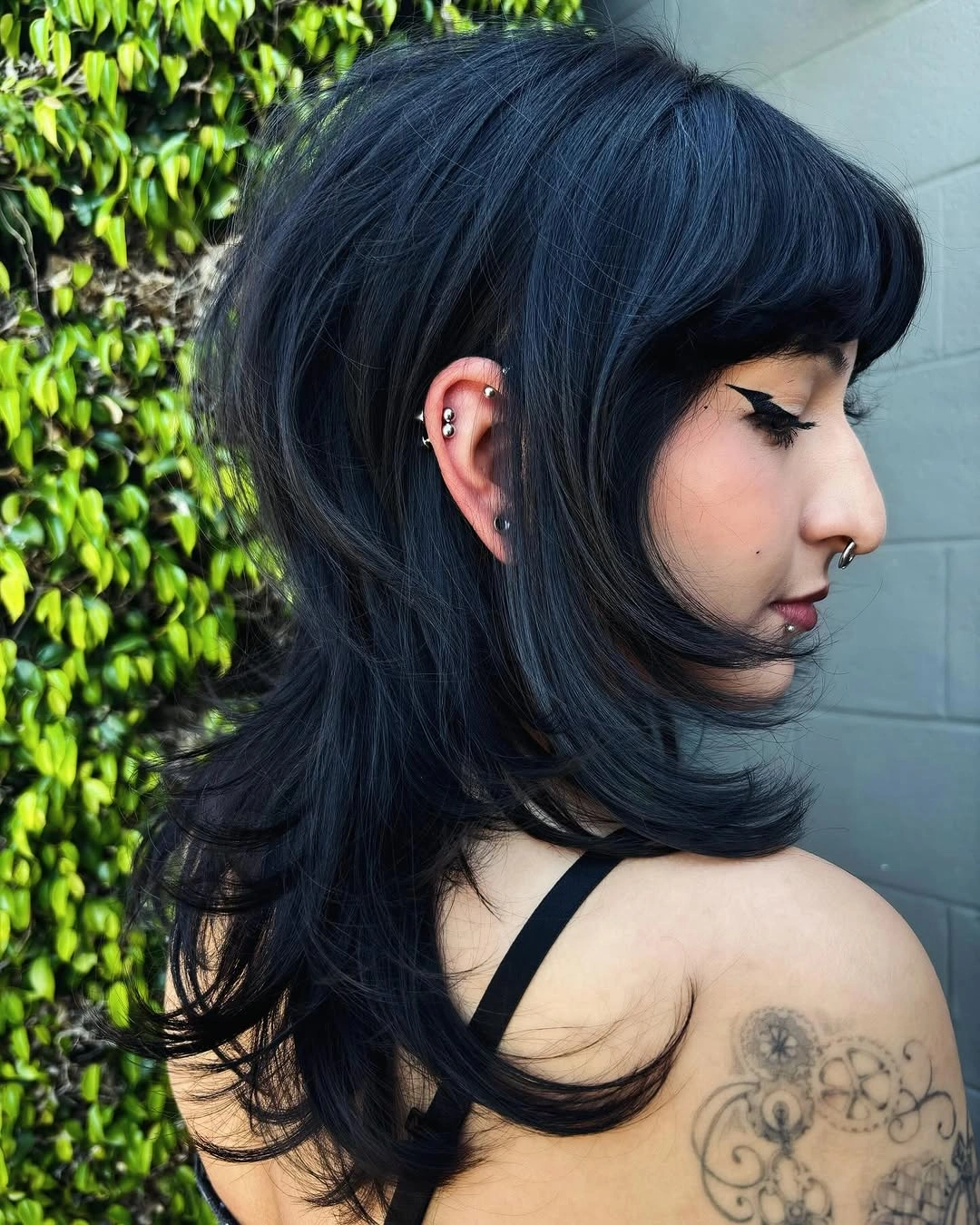 Blue-black side-profile shag with rounded bangs and long nape layers