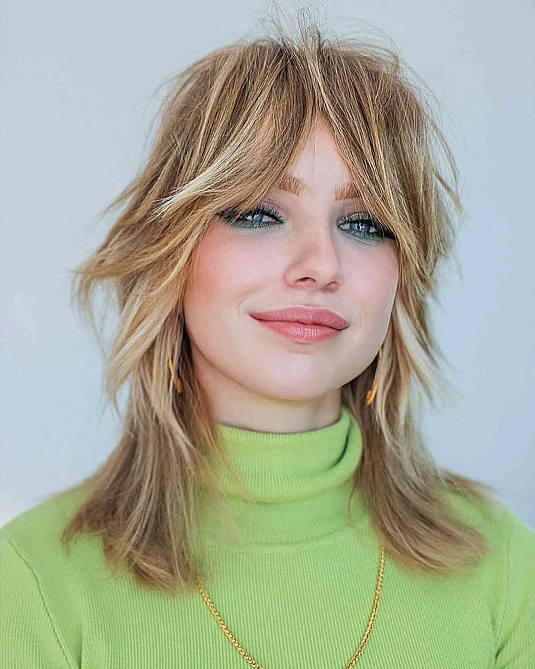 Blonde shoulder-length shag with curtain bangs and flipped piecey ends