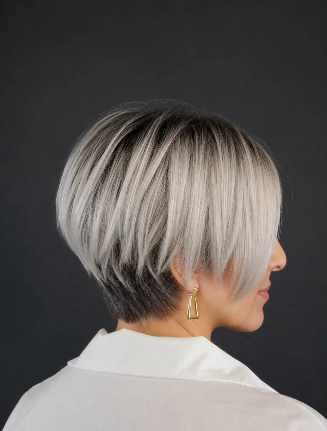 Short silver-gray stacked bob with dark tapered nape