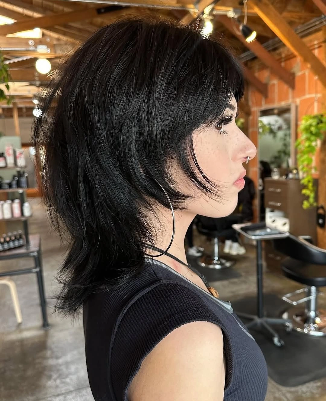 Dark side-profile shag with brow fringe and long flipped nape