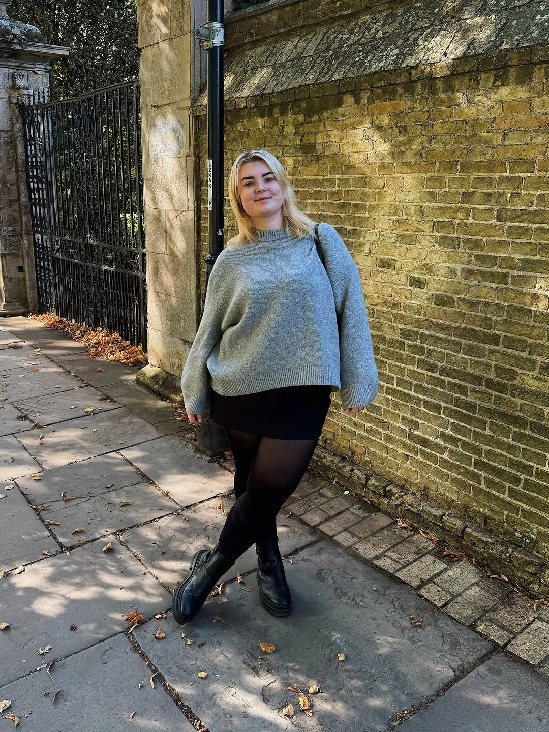 Gray oversized sweater with black skirt tights and boots