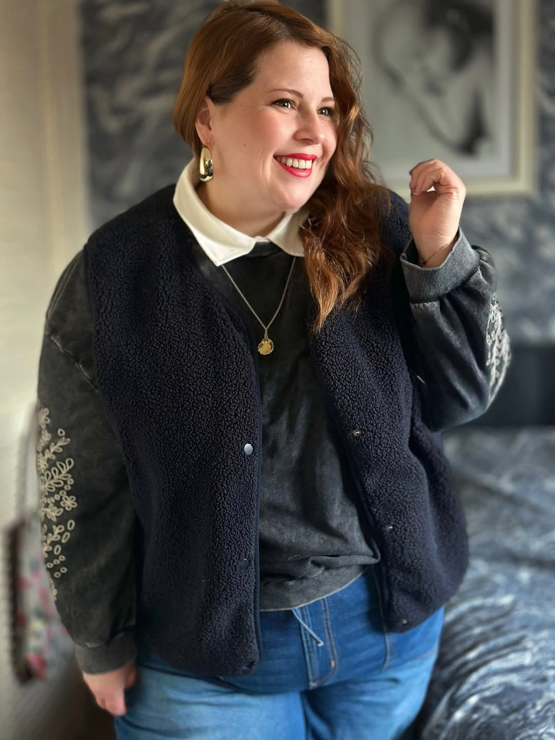 Dark textured vest over collared sweatshirt and jeans