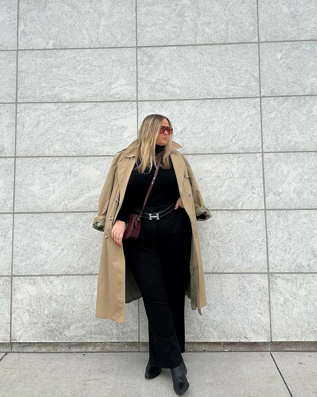 Beige trench coat over black outfit with boots